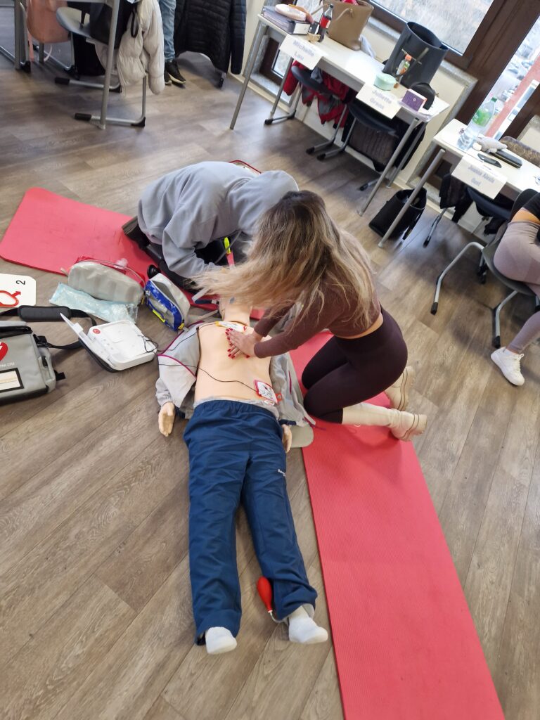 Pflegekraft beim Notfalltraining mit Reanimationsübung im Pflegeheim